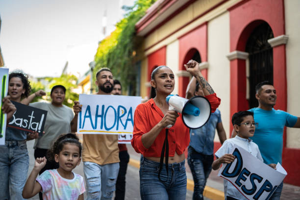 istock Mid adult protester woman leading a demonstration using a megaphone 1436220688
