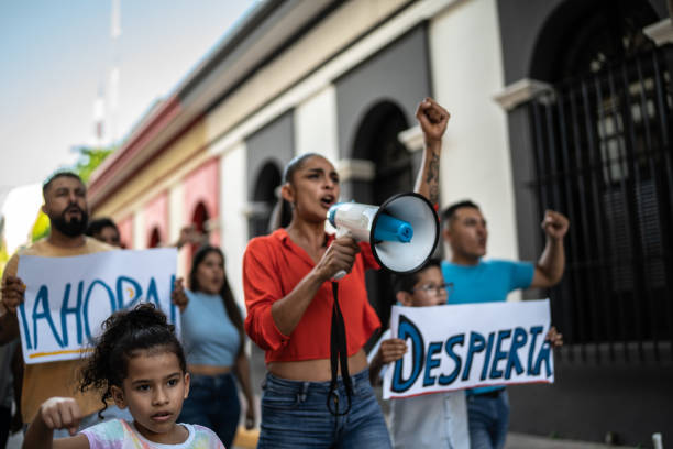 istock Mid adult protester woman leading a demonstration using a megaphone 1436220694