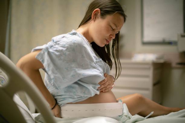 a pregnant woman in the hospital delivery room having contractions. childbirth and labor. - labour room imagens e fotografias de stock