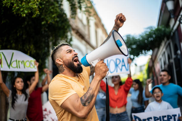 istock Mid adult man leading a demonstration using a megaphone outdoors 1436220965