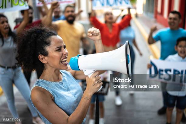 Mid Adult Woman Leading A Demonstration Using A Megaphone Outdoors Stock Photo - Download Image Now