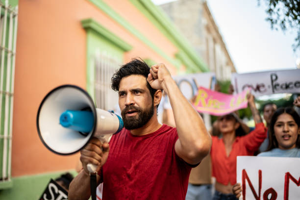 istock Mid adult protester man leading a protest using a megaphone outdoors 1436221885