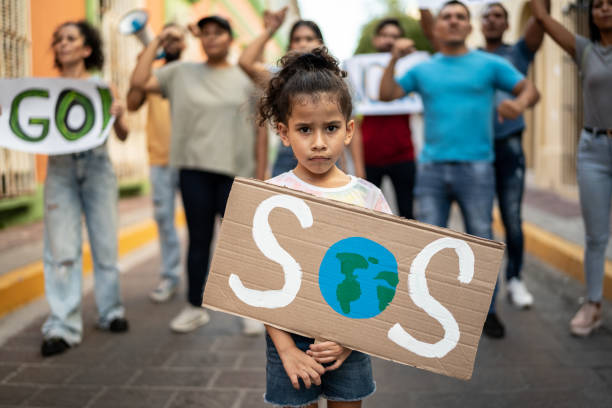 Portrait of child girl holding a sign about the environment on the protest Portrait of child girl holding a sign about the environment on the protest climate justice stock pictures, royalty-free photos & images