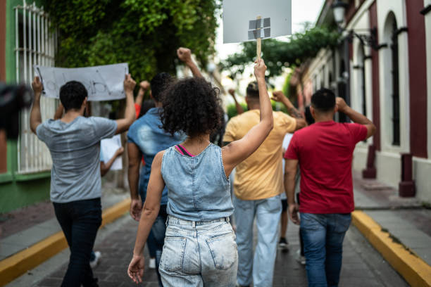 屋外でのデモ中にプラカードを掲げて歩く抗議者 - protest women marching street ストックフォトと画像