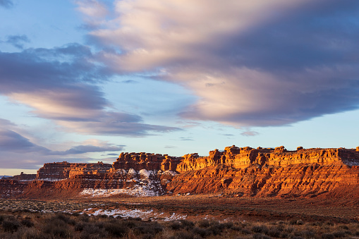 dramatic sky early winter morning in Valley of Gods in Utah as the first light illuminates the buttes and mesas.
