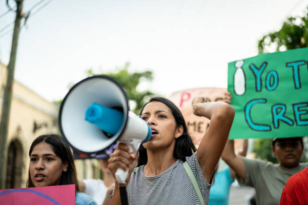 istock Young woman leading a demonstration using a megaphone outdoors 1436227844