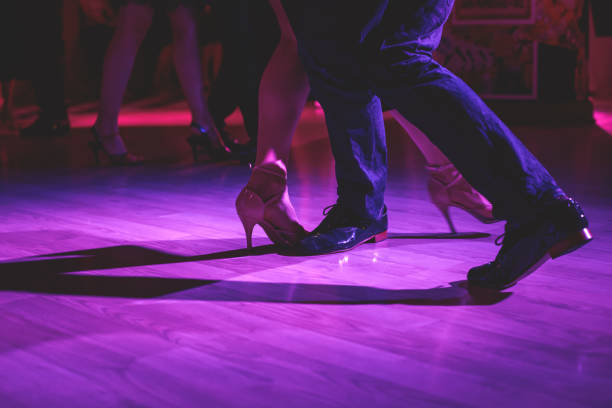 dancing shoes of a couple, couples dancing traditional latin argentinian dance milonga in the ballroom, tango salsa bachata kizomba lesson, festival on a wooden floor, purple, red and violet lights - polka dancing imagens e fotografias de stock