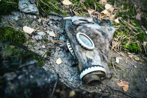 Photo of an old used gas mask lying on a large stone