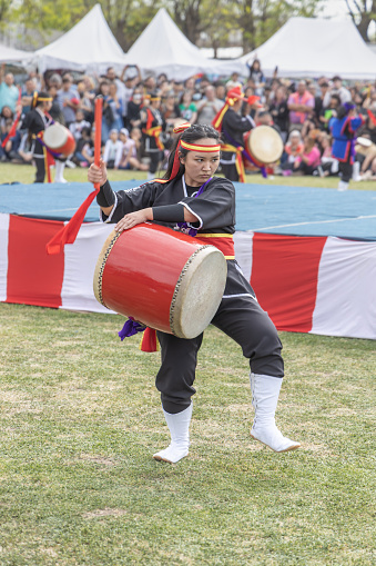 Buenos Aires, Argentina - October 24th, 2022: Young Japanese woman doing the sun salutation. Eisa (Japanese dance with drums) in Varela Matsuri.