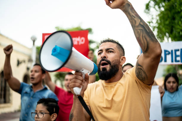 istock Mid adult man leading a demonstration using a megaphone outdoors 1436229786