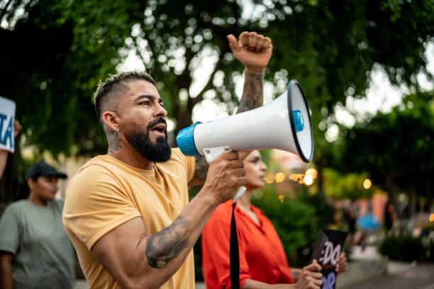 istock Mid adult man leading a demonstration using a megaphone outdoors 1436229892