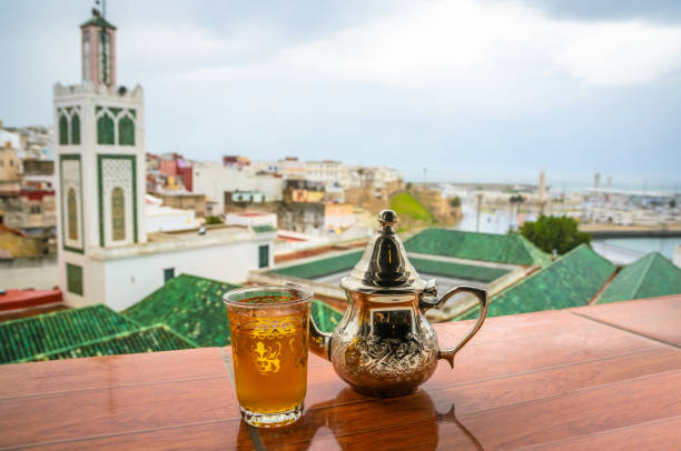 Traditional Moroccan mint tea and panorama of old medina in city Tangier, Morocco Traditional Moroccan mint tea and panorama of old medina in city Tangier, Morocco mint tea stock pictures, royalty-free photos & images