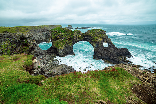 Amazing seascape, Gatklettur basalt rock arch at the volcanic cliff, Atlantic coast of Arnarstapi in the west of Iceland, natural travel background.