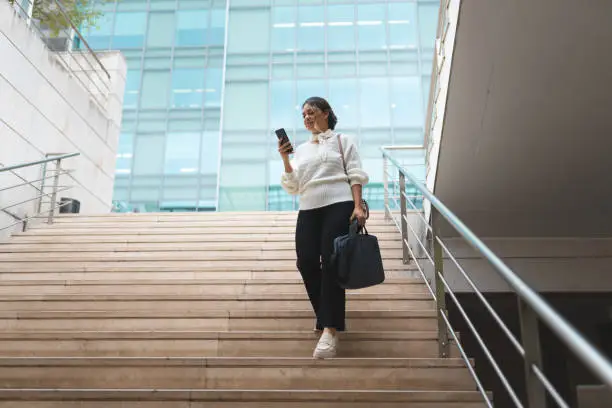 Photo of Businesswoman walking down the stairs of the business building