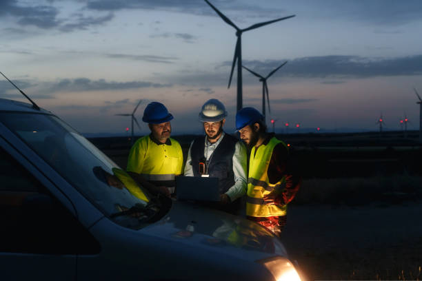 Technicians engineers working in wind turbine electricity plant at night. Renewable energy solution for climate change