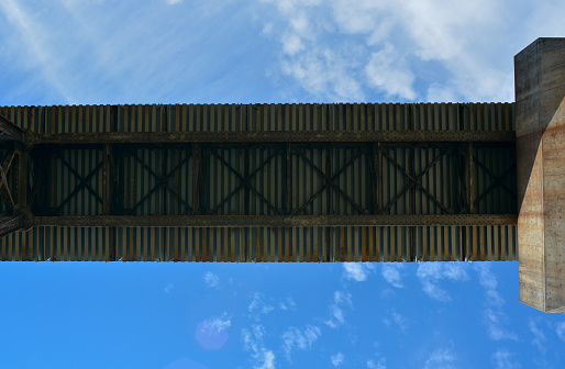 Looking up at the bottom of a train trestle.