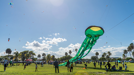 Miami Beach, Florida, USA - October 24, 2022: Colorful Kites Flying in blue spring sky at the Haulover Public Park Kite Festival in Miami Beach.