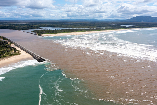 Muddy flood waters from the Macleay river on the north coast of New South Wales flowing into Trial Bay and the Pacific ocean.