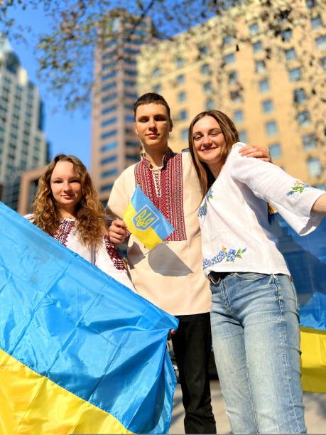 la gente tiene una bandera ucraniana sobre sus hombros en honor a los defenfers de ucrania rally de vancouver galería de arte los ucranianos salieron a las calles contra el terrorismo ruso personas con camisas bordadas - group of people art museum clothing lifestyles fotografías e imágenes de stock