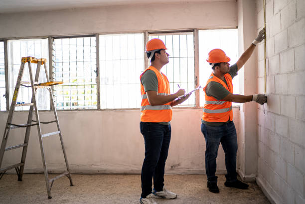 istock Engineers (construction coworkers) measuring a wall and talking indoors 1436253479