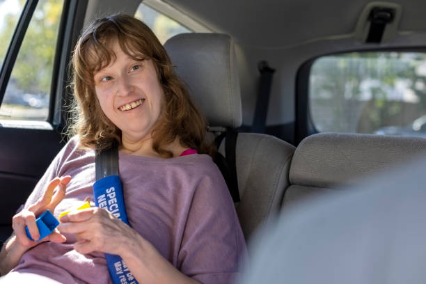 Autistic young woman smiling in the backseat of the car - fotografia de stock