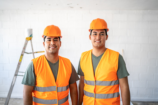 Portrait of young engineers - construction workers indoors