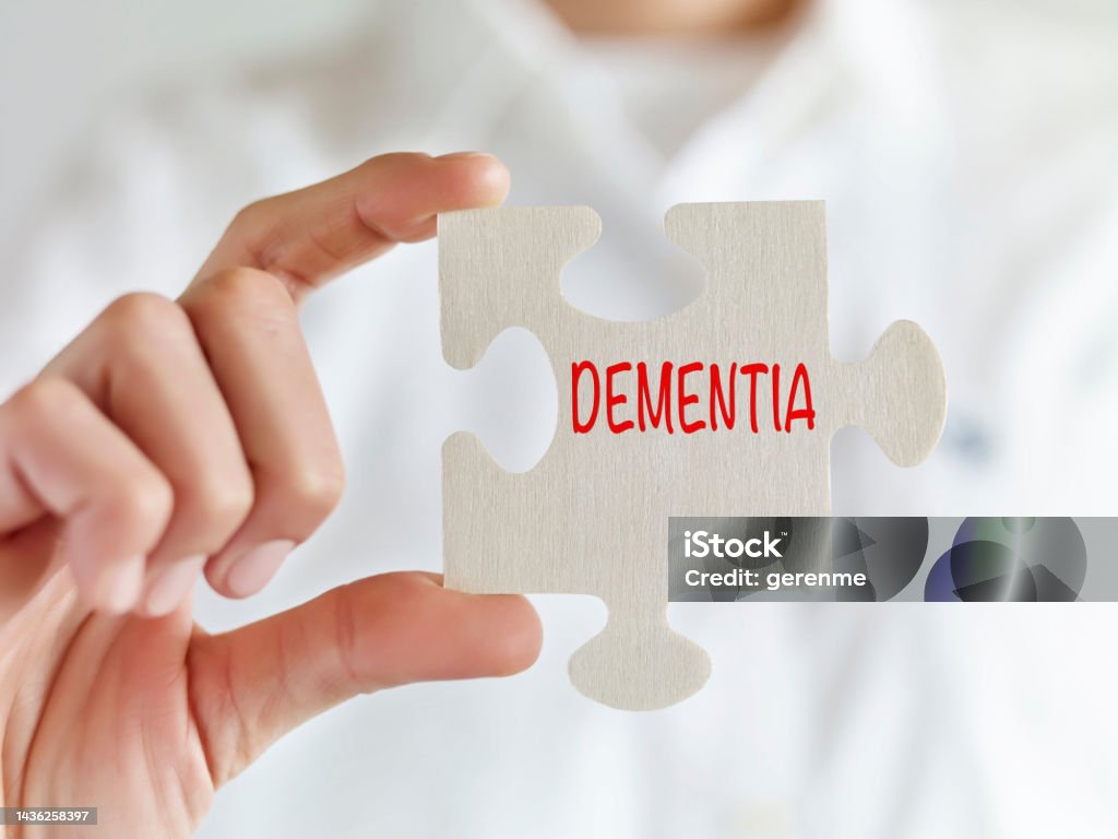 Dementia Woman holding jigsaw puzzle pieces with “Dementia” text Adult Stock Photo
