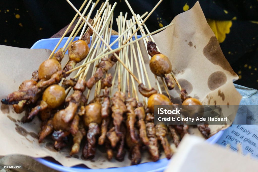 Chicken satay sold along Jalan Malioboro, Yogyakarta. One serving contains ten skewers topped with rice cake or ketupat. Chicken satay sold along Jalan Malioboro, Yogyakarta. One serving contains ten skewers topped with lontong or ketupat. The seasoning used is peanut sauce with the addition of soy sauce and chili sauce. Barbecue - Meal Stock Photo