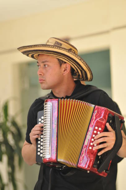 joven tocando un acordeón con un sombreo vueltiao (una especie de sombrero)- acordeón - trajes tipicos colombianos fotografías e imágenes de stock