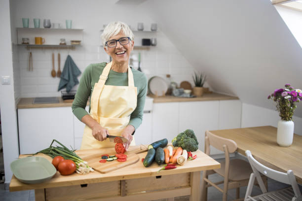 istock Old woman cutting vegetables 1436277286