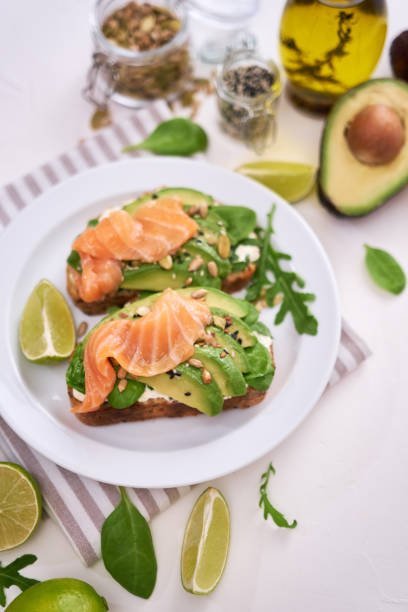 istock Freshly made Avocado, salmon and cream cheese toasts on a white ceramic plate 1436278155