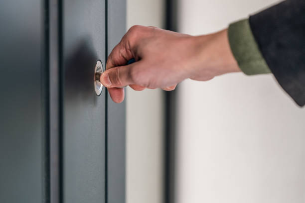 istock Male hand holding key in door lock 1436278186
