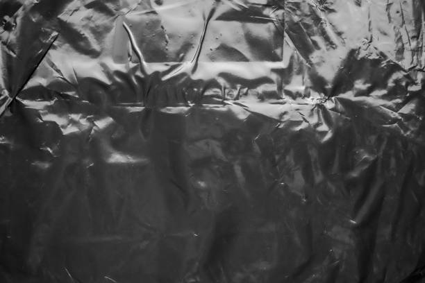 istock transparent plastic bag film wrap overlay texture on black background 1436278343