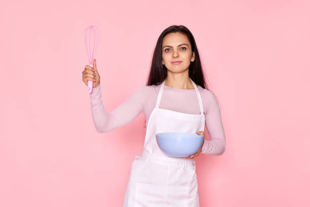 istock woman holding whisk and bowl with eggs 1436279636