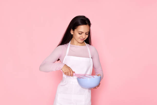 istock woman holding whisk and bowl with eggs 1436279642