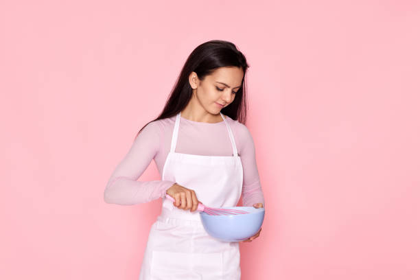 istock woman holding whisk and bowl with eggs 1436279648