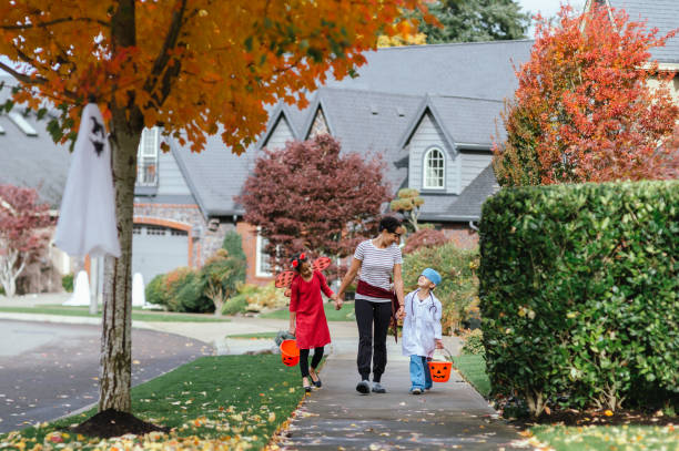 istock Young Family Trick Or Treating Together 1436280164
