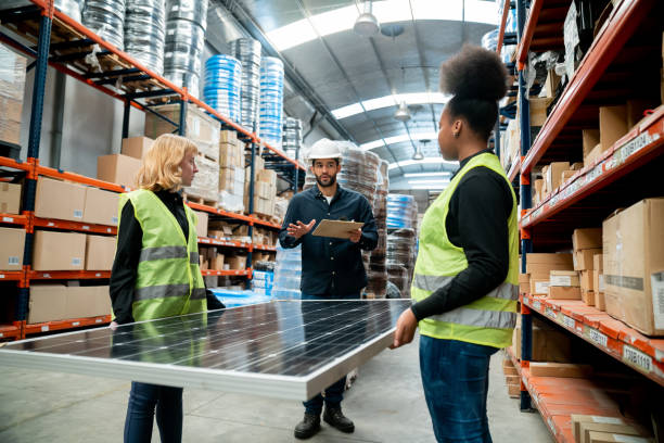 istock Warehouse supervisor giving instructions to female employees carrying a solar panel 1436282819