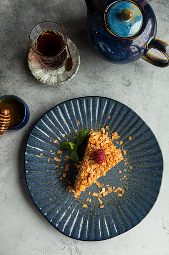 Dobos torte Food and black plate with tea, piece of Hungarian Dobos cake