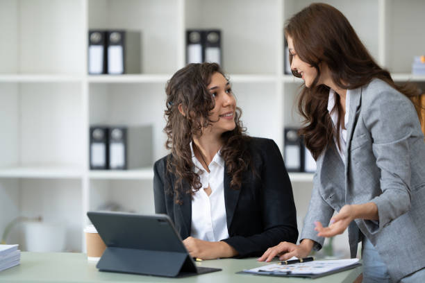 istock Cheerful young female entrepreneur browsing tablet and laptop at workplace in office. 1436295458