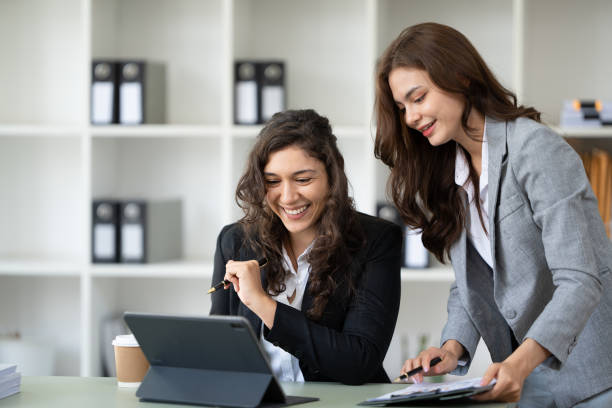 istock Cheerful young female entrepreneur browsing tablet and laptop at workplace in office. 1436295904