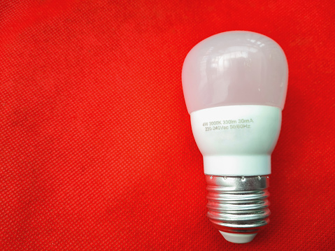 A LED light bulb on red background