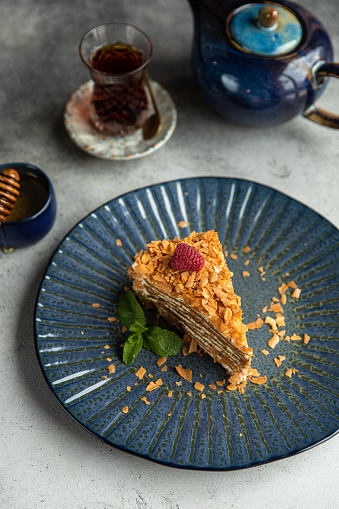 Dobos torte Food and black plate with tea, piece of Hungarian Dobos cake