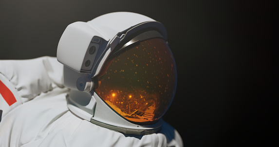 Spaceman in helmet on a black background with a copy space in a mysterious light