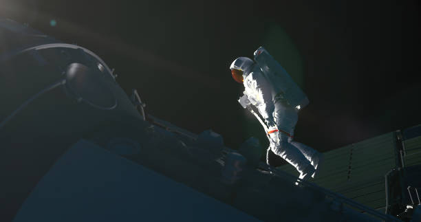 istock Space concept image with astronaut in a white spacesuit at the spacecraft in a sunlight coming from the corner 1436307908