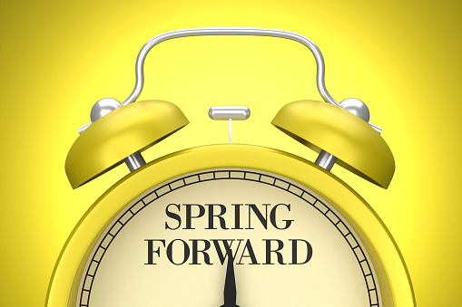 The yellow clock on the yellow background writes Spring Forward. Planning concept.