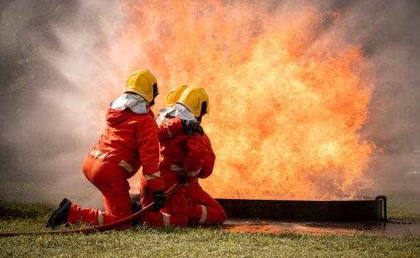 istock firefighter training., fireman using water and extinguisher to fighting with fire flame in an emergency situation., under danger situation all firemen wearing fire fighter suit for safety. 1436312470