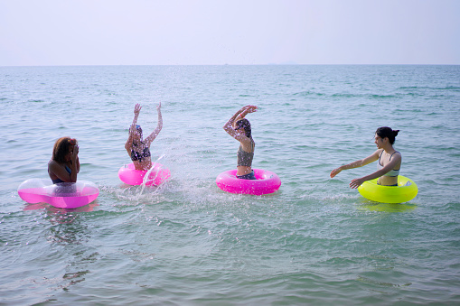 Group of teenage girls are playing on the beach. Beach and holiday concept.