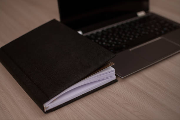 istock Notepad and laptop on a wooden table. 1436324496
