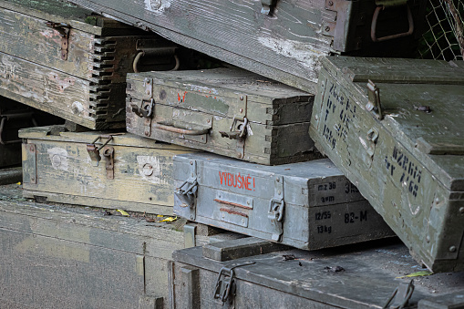 A stack of old wooden military green boxes with ammunition.
